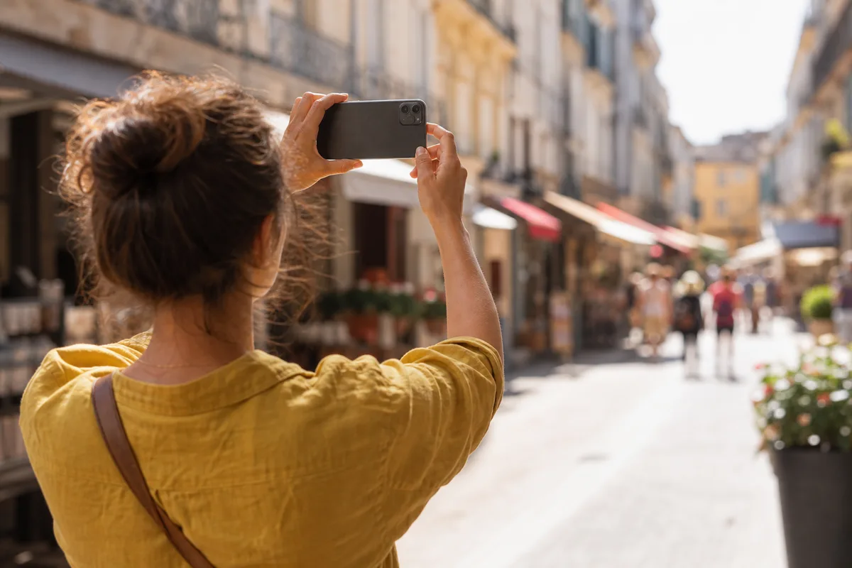 Personne consultant son smartphone dans une rue commerçante