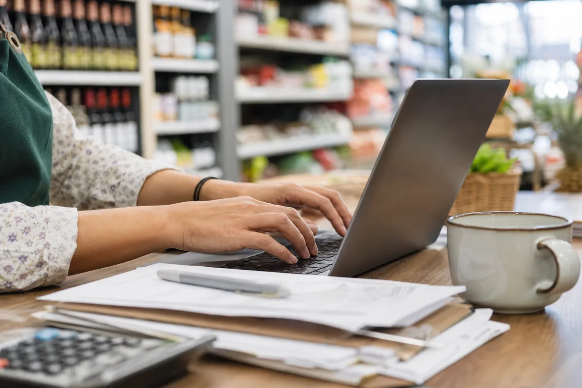 Commerçante remplissant sa déclaration d’embauche sur ordinateur dans sa boutique