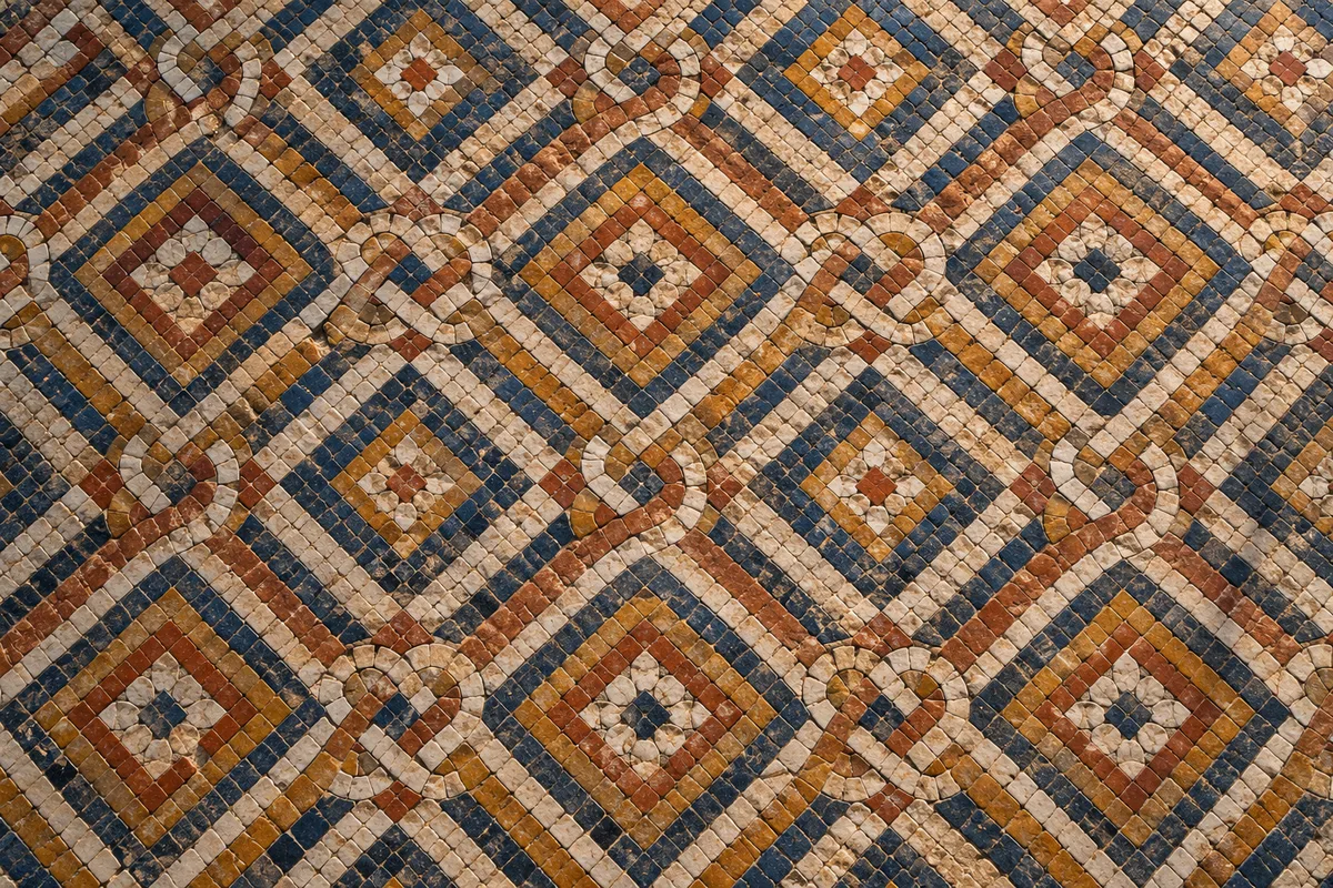 Sol de mosaïque ancienne aux tesselles de couleurs variées assemblées en motif géométrique